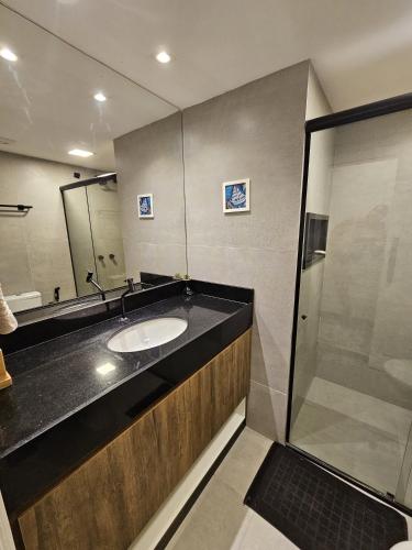 a bathroom with a sink and a shower at Go Eco Paradise Ap210 Pé na Areia e Piscina no Centro do Cumbuco in Caucaia
