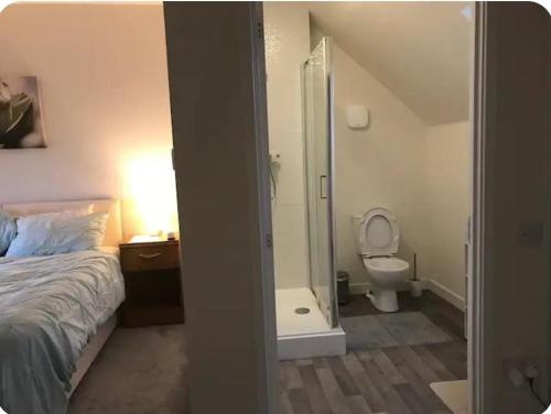 een slaapkamer met een bed en een douche en een toilet bij NG Property in Glasgow