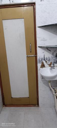 a bathroom with a sliding door and a sink at Shakti HomeStay - Kashi Dham in Varanasi