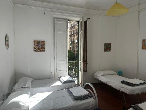 two twin beds in a room with a window at Via Zara Arararooms in Palermo
