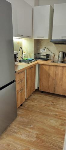 een keuken met houten werkbladen en witte kasten bij Apartamenty na Witosa in Nowa Sól