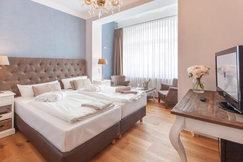 ein Schlafzimmer mit einem großen Bett und einem Fernseher in der Unterkunft freustil Boutique Hotel in Binz