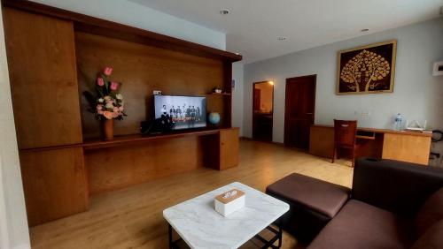 a living room with a couch and a tv at Aonang Peace Pool Villa in Ban Khlong Haeng