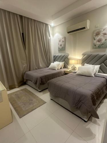 een slaapkamer met 2 bedden en een bank bij منتجع هوانا غرفتين in Salalah