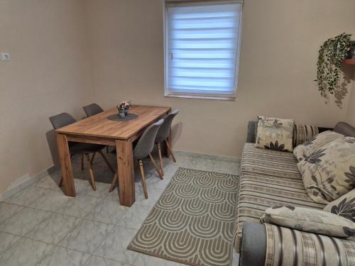 ein Wohnzimmer mit einem Holztisch und einer Couch in der Unterkunft Tóthék Apartman in Szigetvár