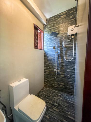 a bathroom with a toilet and a shower at Black Lantern in Matara