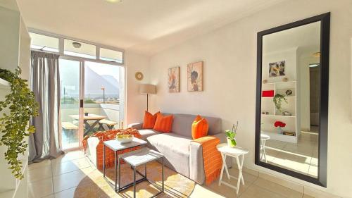 a living room with a couch and a large mirror at Steps from the beach , Muizenberg home in Muizenberg