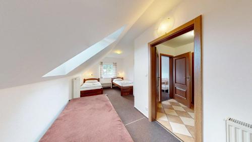 een zolderkamer met een gang met een raam en een slaapkamer bij Javorník 88 in Javorník