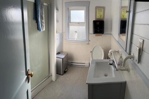 a bathroom with a sink and a toilet and a window at Tofino Paddlers Inn in Tofino