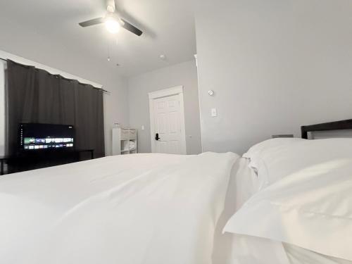 a bedroom with two white beds and a ceiling fan at The Uno Room first floor 10 min d-town 15 airport in Cleveland