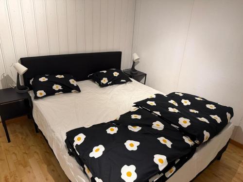 un letto con una coperta nera con fiori bianchi sopra di Amazing cozy apartment 