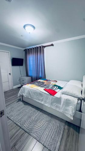 a bedroom with a bed with a rug on the floor at Explore Rooms JFK in Locust Manor