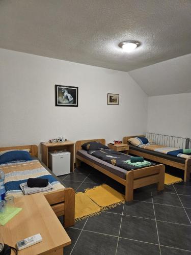 a room with three beds and tables in it at Villa Hukic in Tuzla