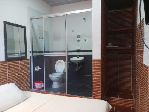 a bathroom with a toilet and a sink at Hotel KAMELLON in Estación El Salto