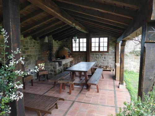 an outdoor patio with a wooden table and benches at Casona de Gómez y Terán in Renedo