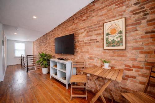 a brick wall with a television and a table at Artsy Hidden Gem - FREE PARKING in Philadelphia