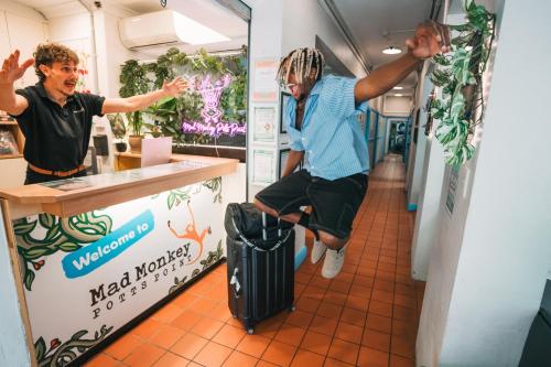 a man sitting on a suitcase in front of a counter at Mad Monkey Potts Point in Sydney