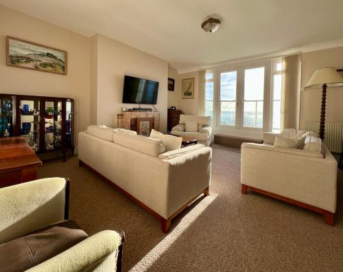 a living room with two couches and a tv at Clifton Views in Folkestone