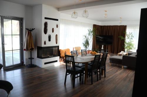 een woonkamer met een tafel, stoelen en een bank bij Vila Bella in Oradea