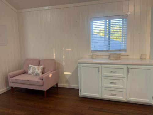 un salon avec une chaise et une fenêtre dans l'établissement Tickled Pink, à Harbour Island