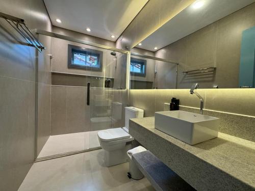 een badkamer met een toilet, een wastafel en een douche bij Pousada Chácara Das Acácias in Paraty