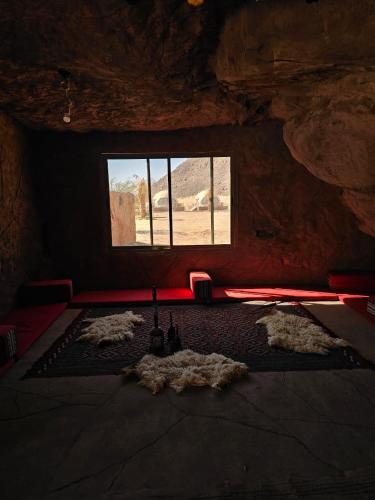 a room with a room with a window in a cave at Ajyad Rum Camp in Wadi Rum