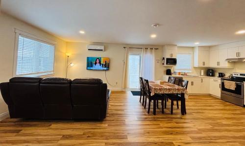 a living room with a dining table and a kitchen at New Guesthouse in Charlottetown
