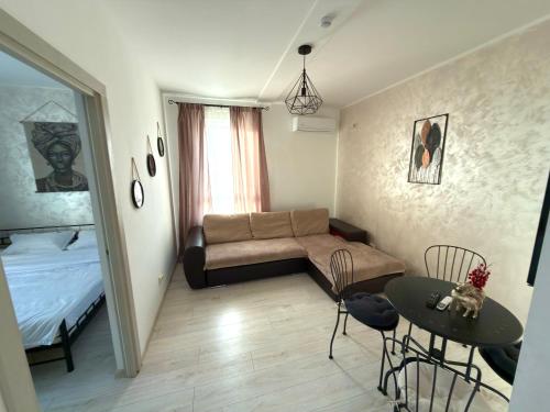 een kleine woonkamer met een bank en een tafel bij Cleo Residence 3 Ghiroda in Ghiroda