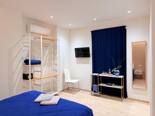 een slaapkamer met een blauw bed en een bureau met een stoel bij DalGra room e garden in Torrevecchia Teatina