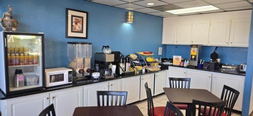 una cucina con mobili bianchi, tavolo e sedie di Days Inn by Wyndham Elberton a Elberton