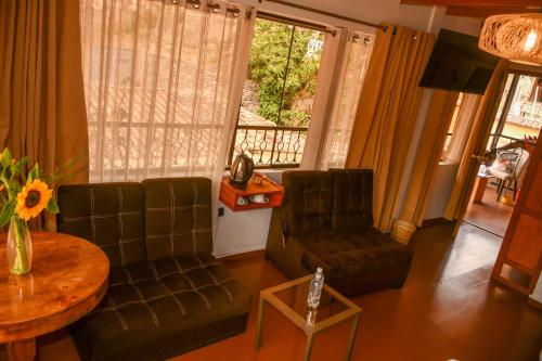 un soggiorno con un divano, sedie e un tavolo di Hotel Boutique MIRANDO AL SOL a Ollantaytambo