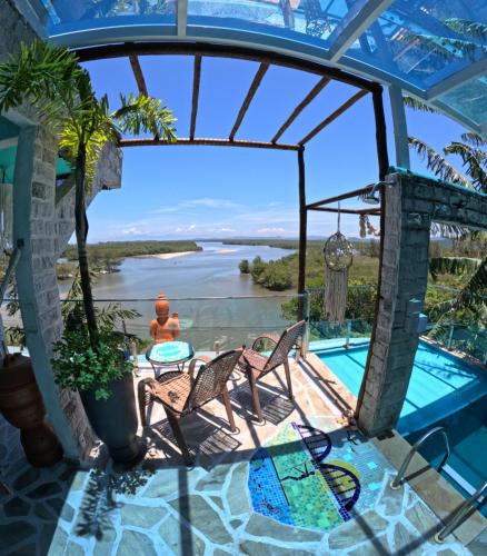 een uitzicht vanaf de patio van een huis met een zwembad bij Vila Paisagem in Barra de Guaratiba