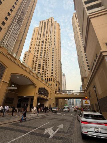 een stadsstraat met hoge gebouwen en een brug bij Nuchi Jbr Hostel in Dubai