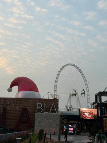 Een kerstmuts bovenop een gebouw met een reuzenrad. bij Nuchi Jbr Hostel in Dubai