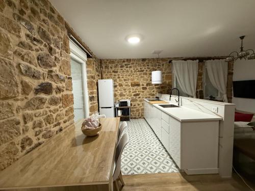 een keuken met een tafel en een stenen muur bij Bibelot in Reinosa