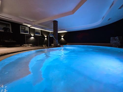 een groot blauw zwembad in een gebouw bij Hotel Lärchenhof in Kaunertal