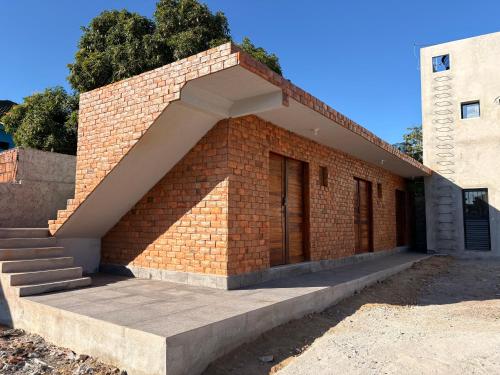 ein Backsteingebäude mit einer Treppe und einer Tür in der Unterkunft Pousada Serena Jacumã in Conde