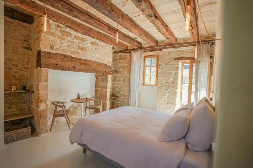 een slaapkamer met een wit bed in een bakstenen muur bij MAISON LOU PIADE Sarlat Your Luxury Farm Hôtel & Confidential place to stay in Sarlat in Sarlat-la-Canéda