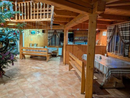 een restaurant met houten tafels en banken en een bar bij У Павла in Yablunytsia