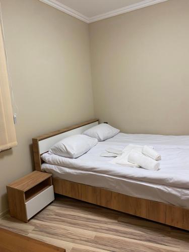 una camera da letto con un letto con lenzuola e asciugamani bianchi di Elite Guesthouse a Pʼarakʼar