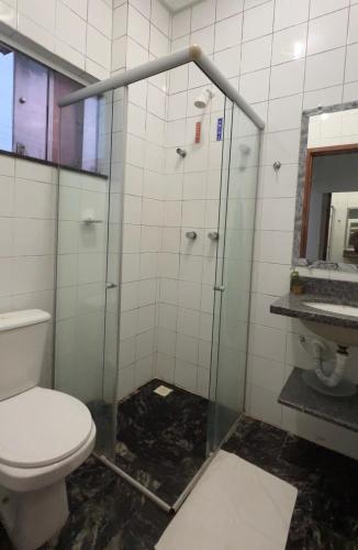 a bathroom with a toilet and a glass shower at Hotel e Conveniência G3 in Teixeira de Freitas