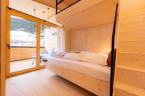une chambre avec un lit dans une pièce avec une fenêtre dans l'établissement Hugo und Pepi Appartements, à Mittelberg