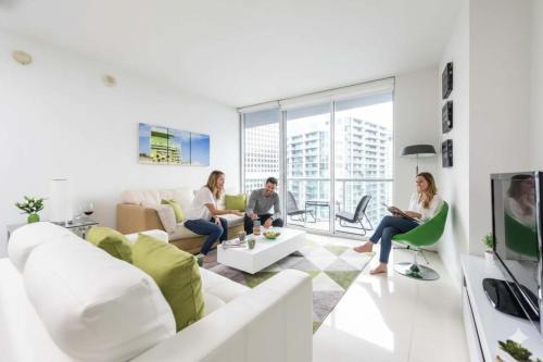 eine Gruppe von Menschen sitzt in einem Wohnzimmer in der Unterkunft Waterfront Spacious Luxury 1 Bedroom IconBrickell in Miami