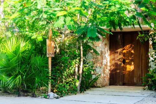 a sign on a pole in front of a building at Teva Tulum, Aldea Zamá in Tulum