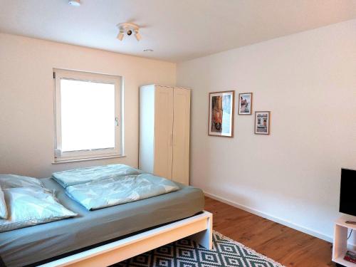 een slaapkamer met een bed en een raam bij Apartment am Fuchseck in Schorndorf