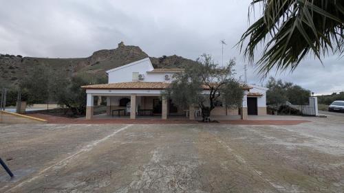 ein weißes Gebäude mit einem Berg im Hintergrund in der Unterkunft Casa rural Huertas del Castillo in Benamejí