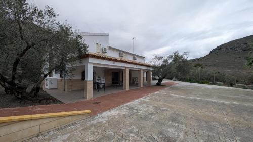 ein großes weißes Gebäude mit einer Auffahrt davor in der Unterkunft Casa rural Huertas del Castillo in Benamejí
