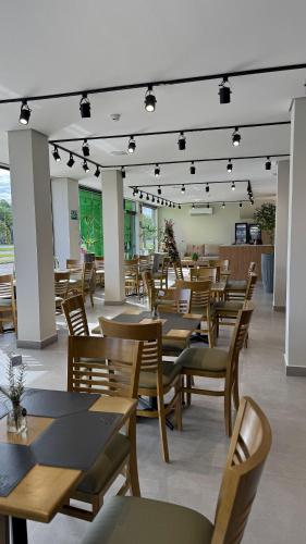 a restaurant with wooden tables and chairs and lights at Nature Bonito Hotel in Bonito