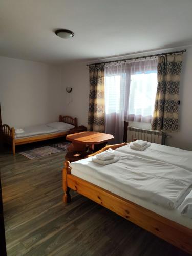 a bedroom with a bed and a table and a window at Chalúpka Paci in Ždiar
