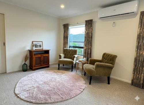 a living room with two chairs and a rug at Wellington Suburb Stay in Wellington